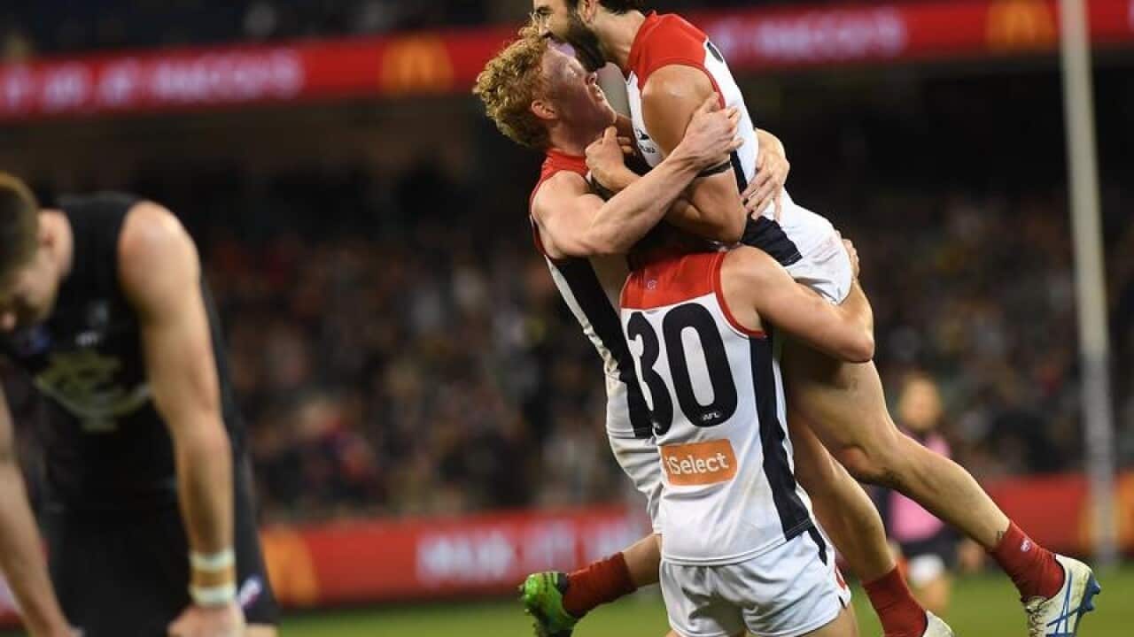 Jordan Lewis is engulfed by teammates
