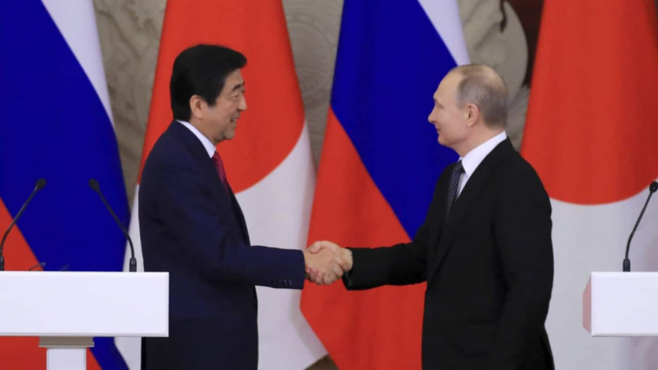 Russian President Vladimir Putin (R) and Japanese PM Shinzo Abe