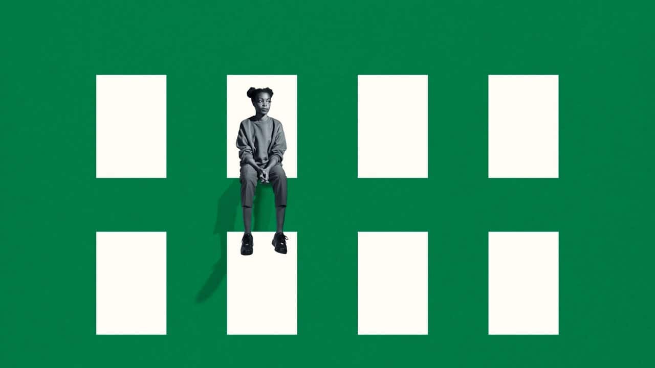 A young woman sitting on green grid window