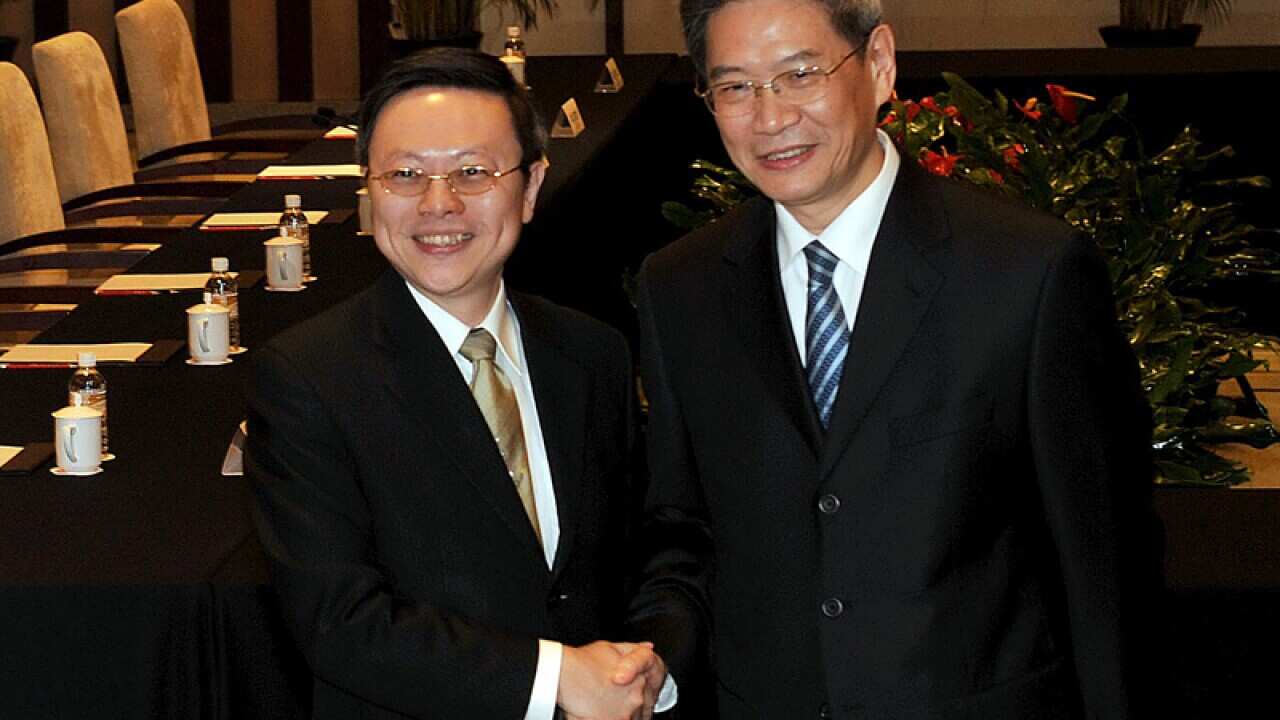 Wang Yu-chi of Taiwan shakes hands with Zhang Zhijun of China.