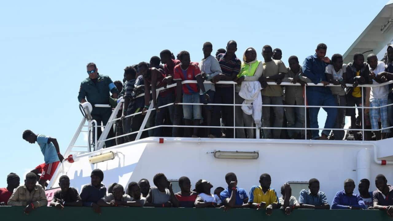 Migrants wait to disembark from the Spanish ship 'Rio Segura' in the harbour of Salerno, Italy, 29 June 2017