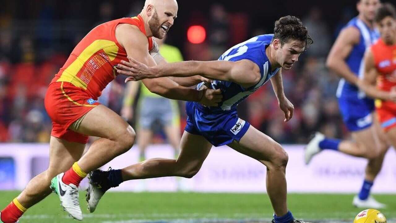 Gary Ablett competes with Kangaroo's player Declan Mountford