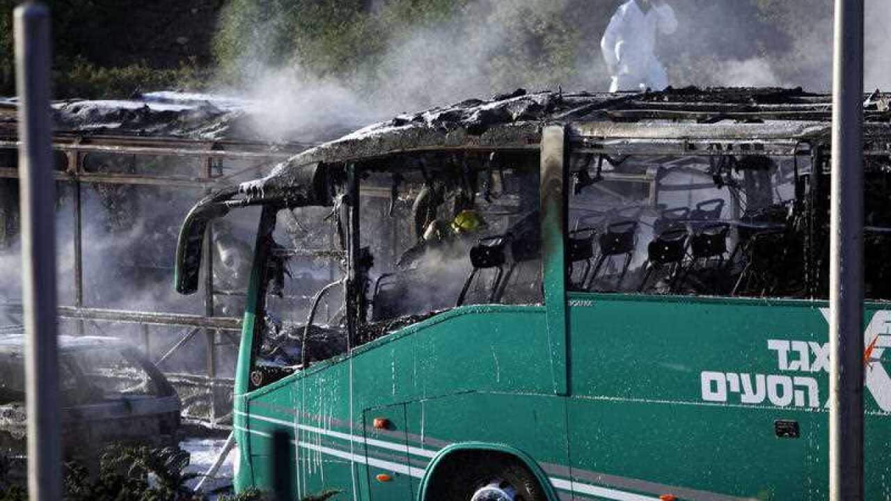 An Israeli firefighter is seen inside a burnt bus in Jerusalem, Monday, April 18, 2016.