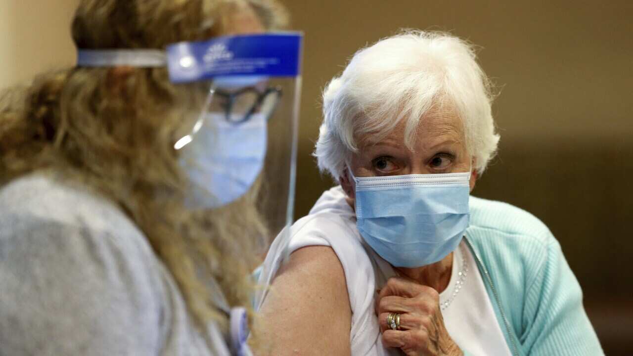 A woman receives her first dose of the COVID-19 vaccine.