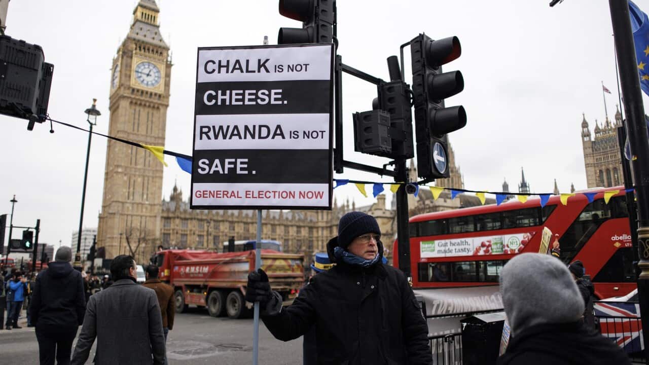 Protesters display placards against the UK government’s Rwanda scheme (AAP)