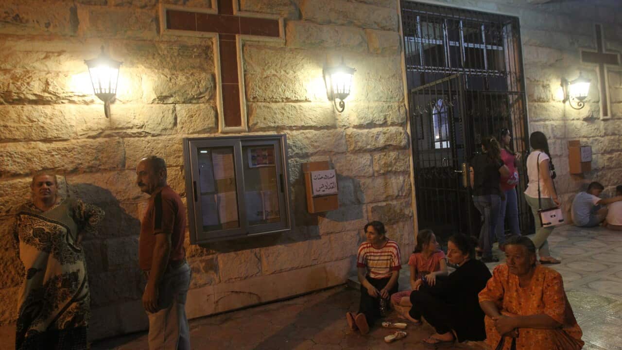 Displaced Iraqi Christians, who fled the violence in the city of Mosul, sit outside the Saint Joseph church in Erbil, the capital of the Kurdish region of northern Iraq, on August 20, 2014. (AHMAD AL-RUBAYE/AFP/Getty)