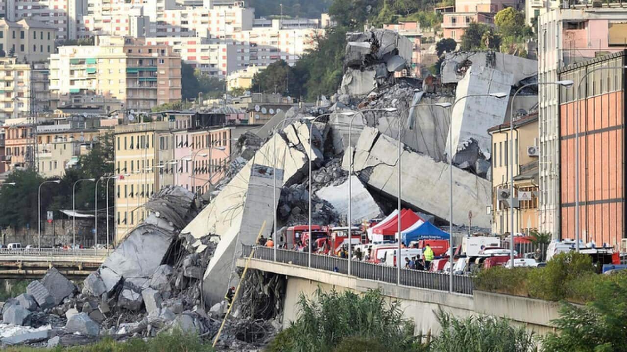 Rescuers work to recover an injured person after the Morandi highway bridge collapsed in Genoa, northern Italy, Tuesday, Aug. 14, 2018. 