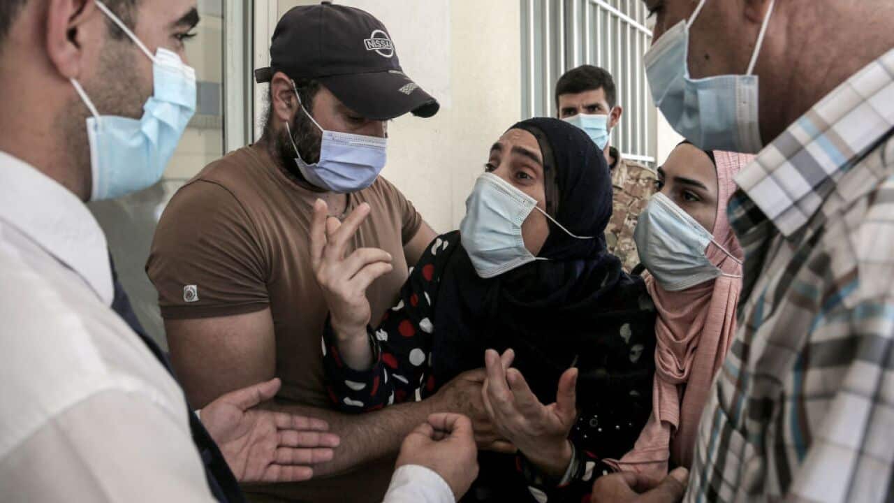 A mother of a severely burned son weeps outside a local hospital after the fuel tank explosion.