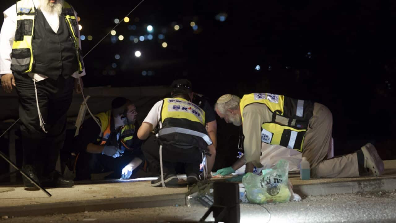 Israeli medics clean up the scene of a fatal stabbing in the West bank