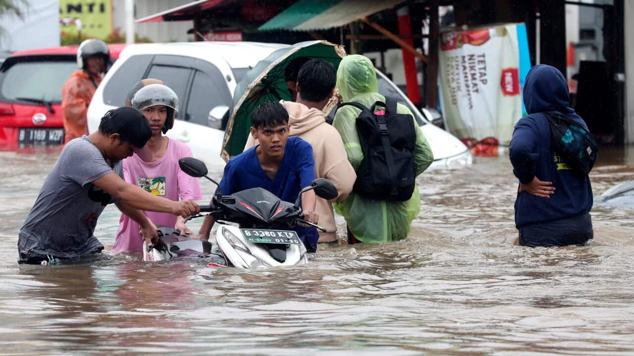 Indonesian people wade through floodwaters at Jatibening outskirt of Jakarta, Indonesia.