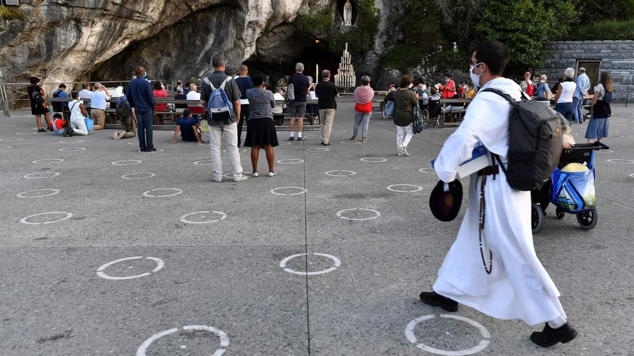 Social distancing is enforced for people praying at Lourdes with circles on the ground
