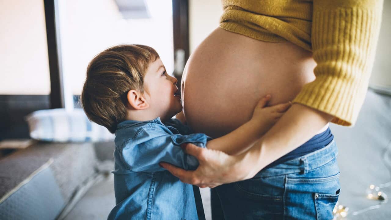 A pregnant woman and a child