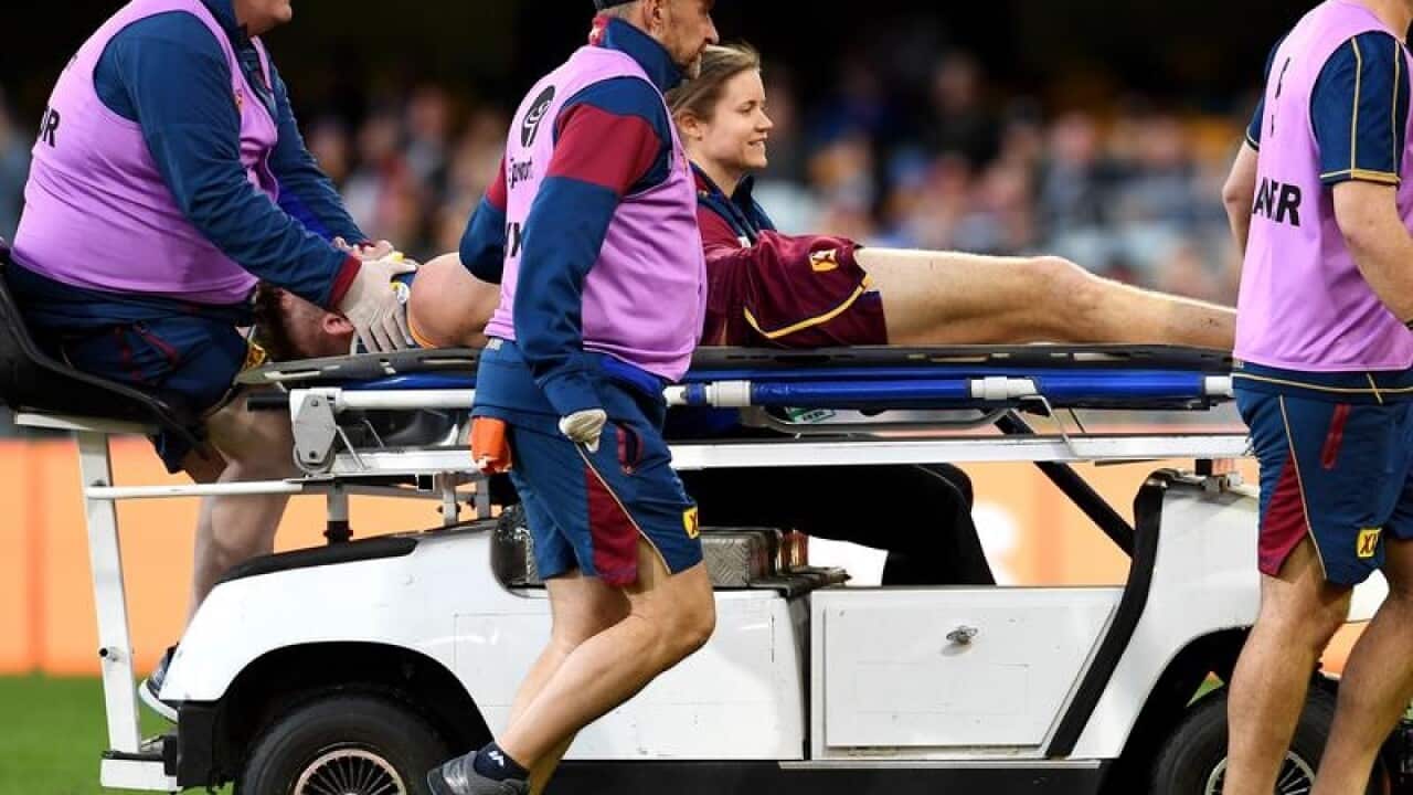 Harris Andrews of the Lions is taken off the field.