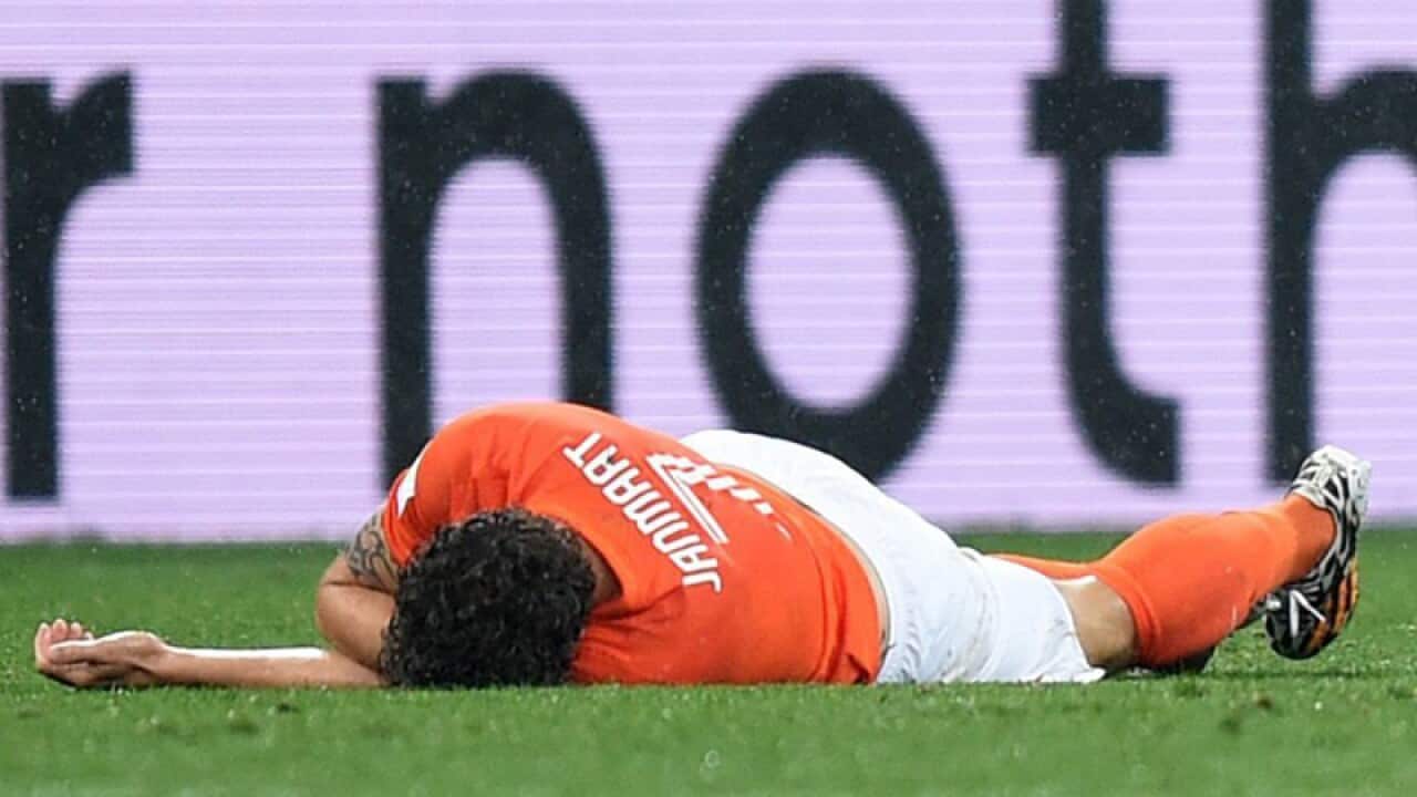 Dutch soccer player Daryl Janmaat lies on the pitch