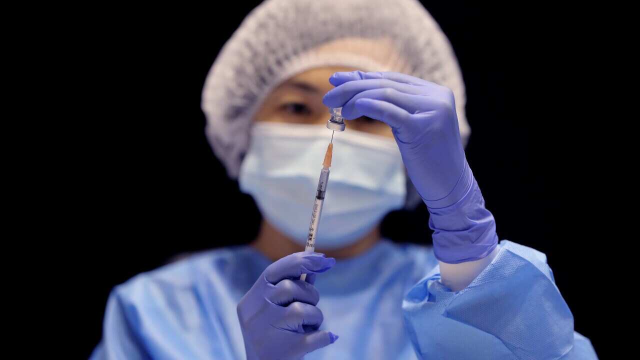 A healthcare worker fills a syringe with the Pfizer vaccine on the opening day of a COVID-19 mass vaccination clinic in Perth, 16 August, 2021.