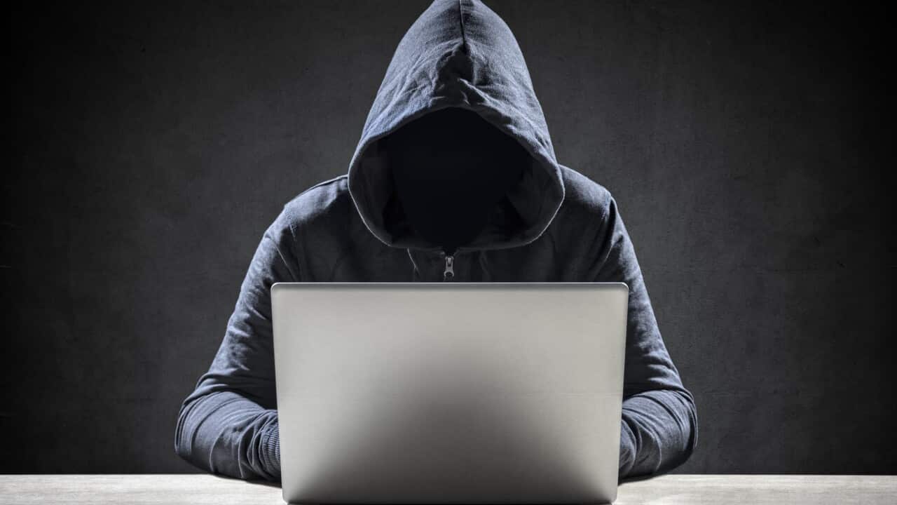 Computer hacker stealing data from a laptop