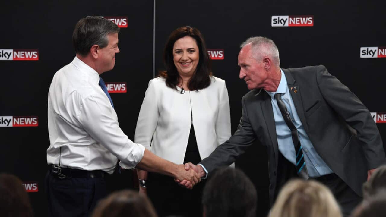 Queensland Premier Annastacia Palaszczuk watches Leader of the Opposition Tim Nicholls shaking hands with One Nation's Steve Dickson during the debate.