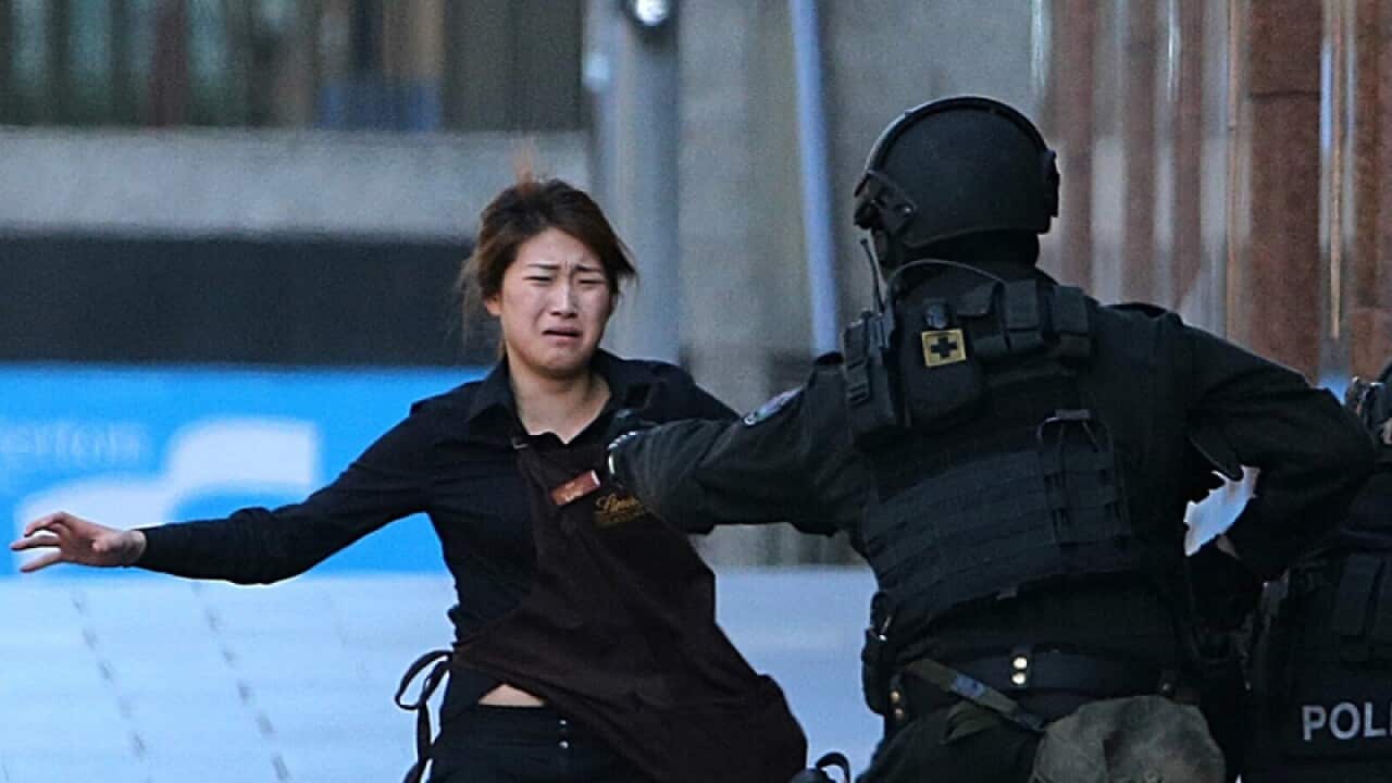 a hostage runs for safety during The Lindt Cafe under siege
