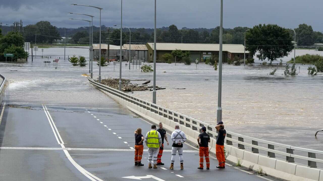 State emergency staff stand near the entrance to the flooded Windsor bridge on the outskirts of Sydney.