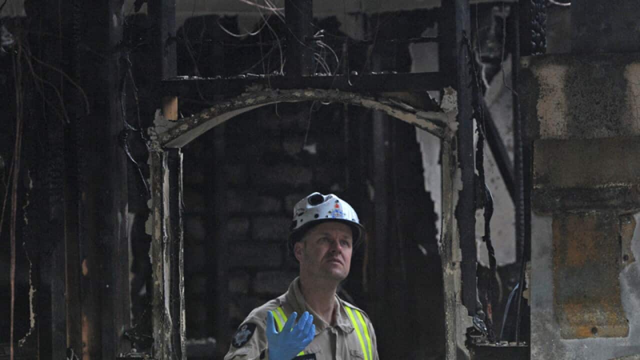 Fire investigators inspect the scene of a house fire in Deer Park