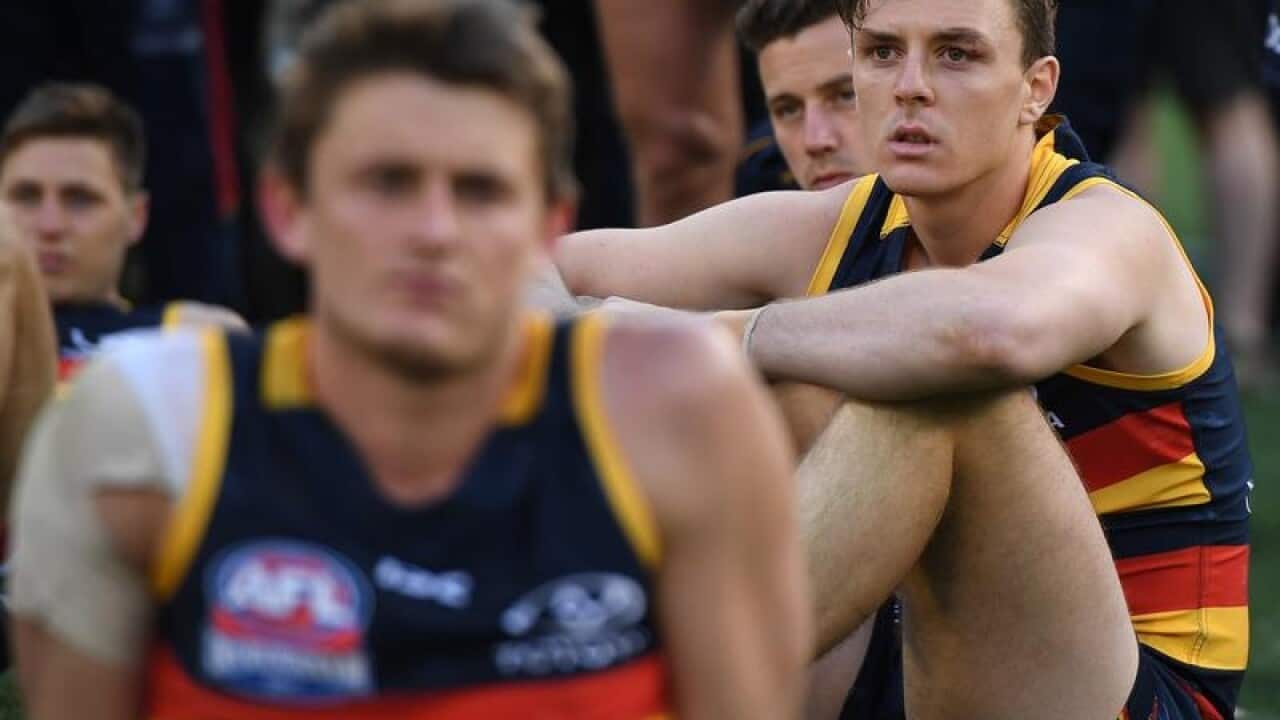 Crows players react after losing the AFL grand final