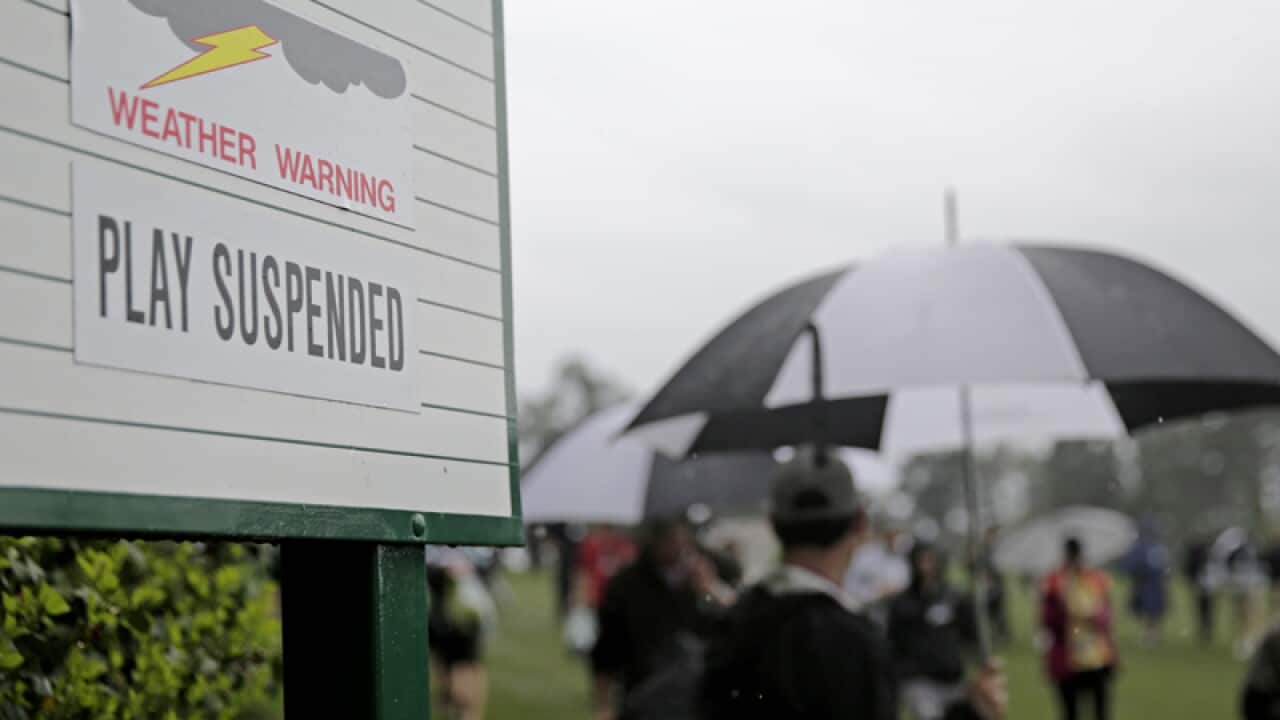 A sign showing play is suspended due to weather