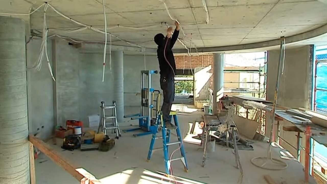 A migrant worker installing electrical circuits