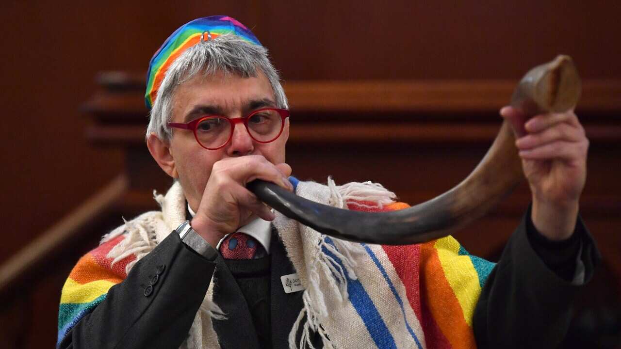 Rabbi Jonathan Keren-Black uses a rabbinical horn (shofar) to sound the end of the era of coal.