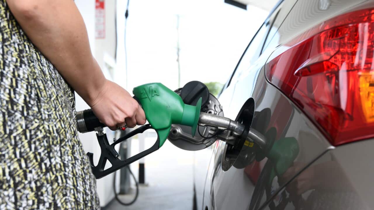 A motorist refuels her car at a service station in Brisbane