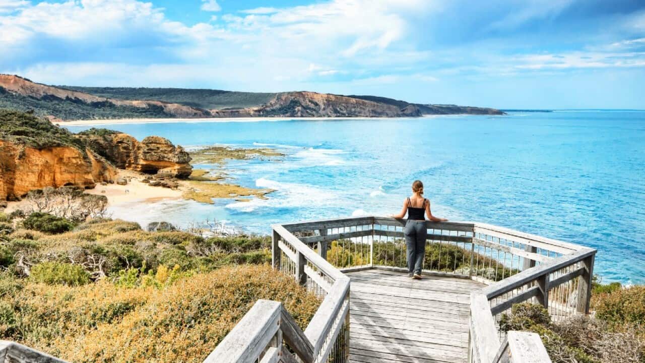 A woman looking down at a beach neary Torquay, Victoria.