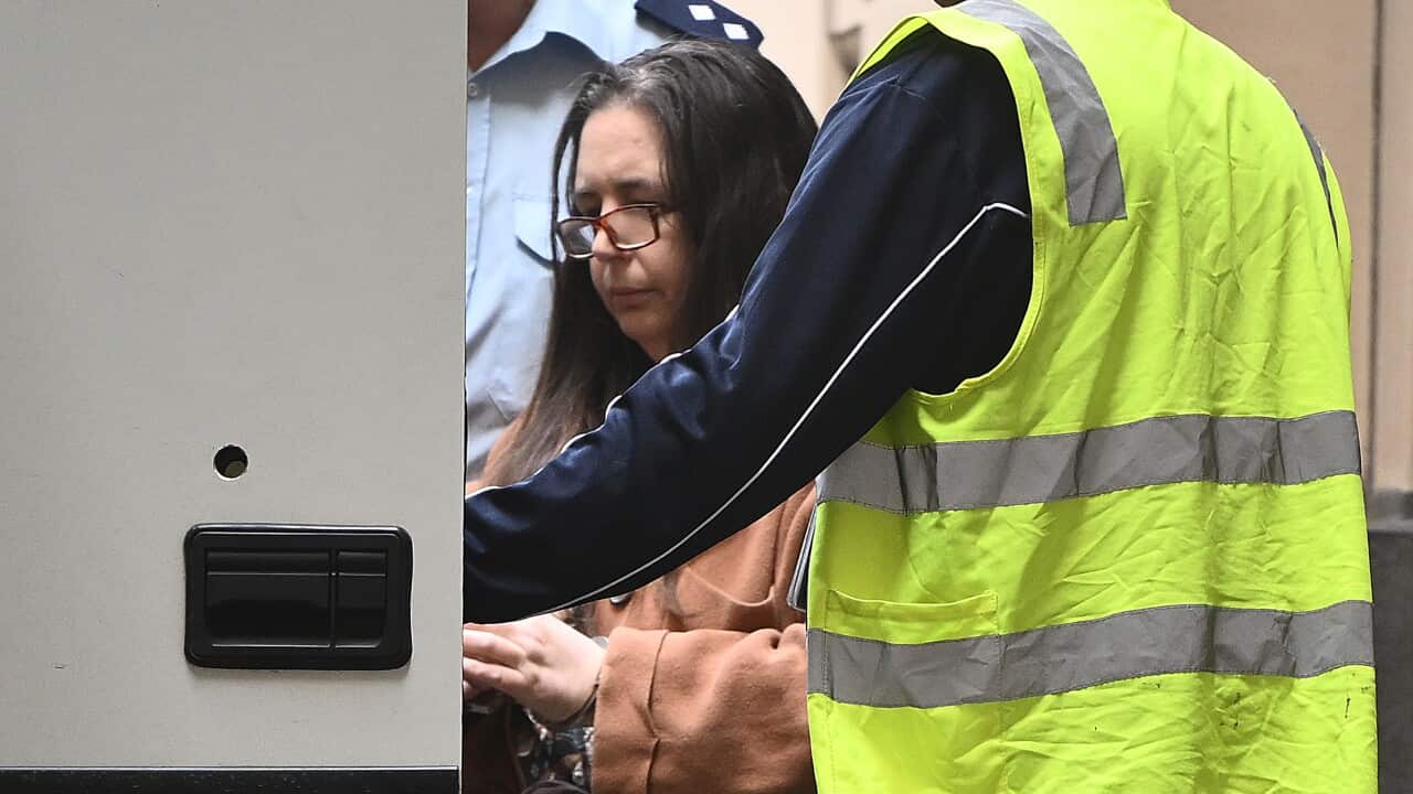 Erin Patterson near a man wearing a high visibility vest as she enters a vehicle.