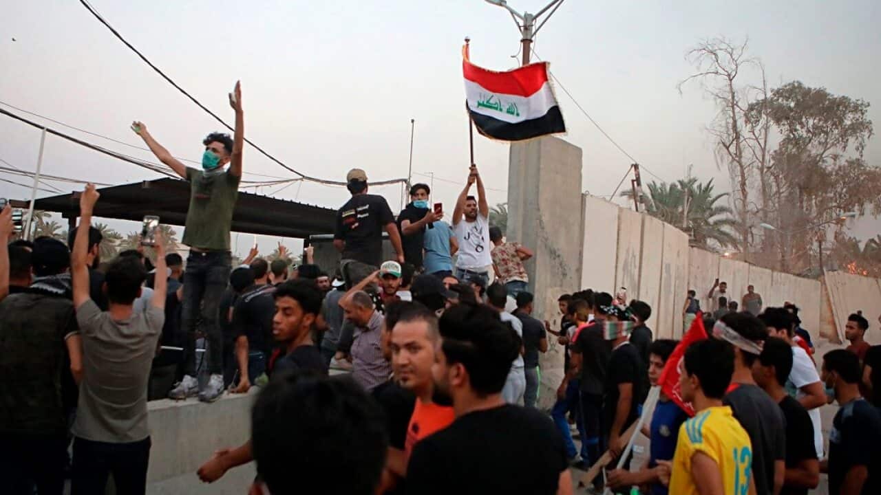 Protesters raise the Iraqi flag at the gate of the Iranian consulate building before storming and burning it in Basra.