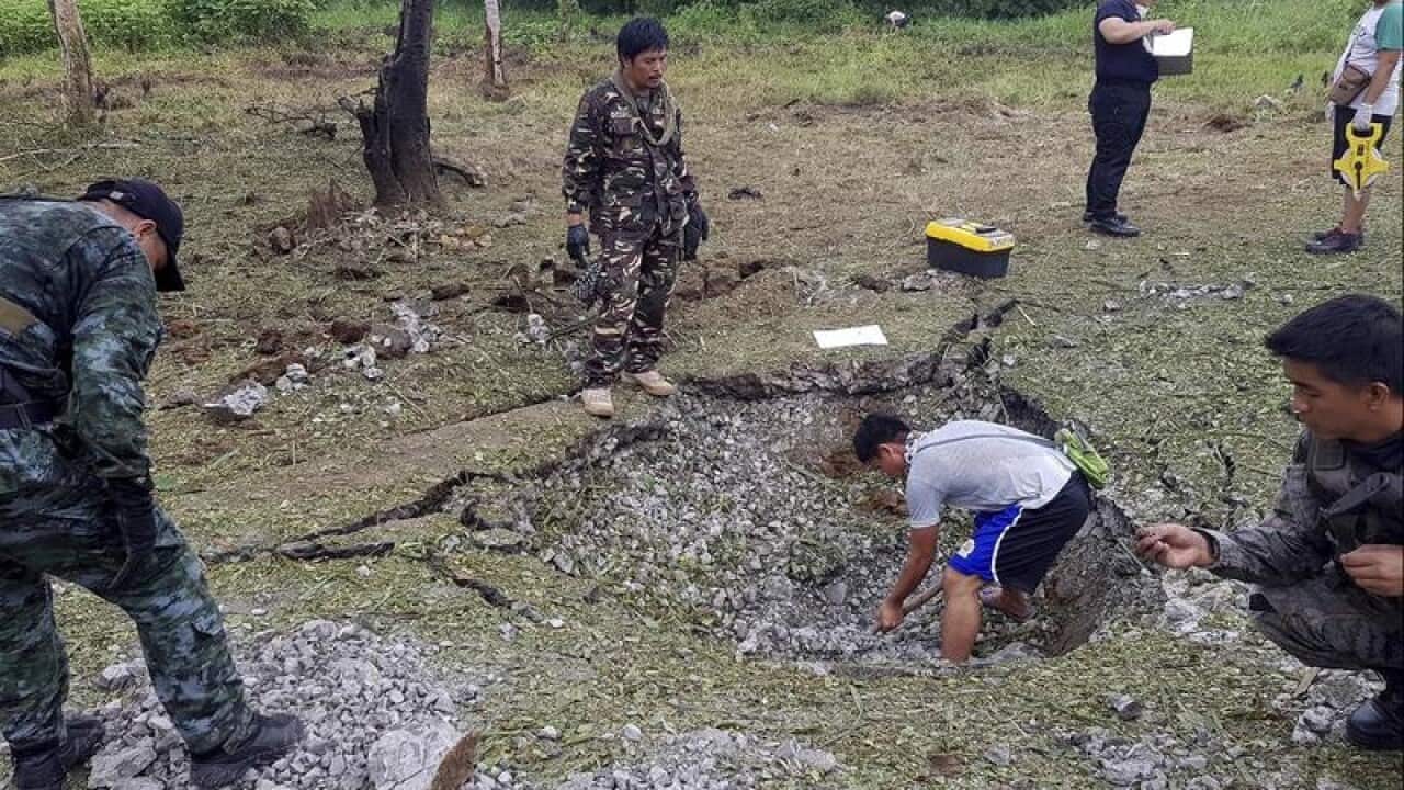 Men searching the blast site