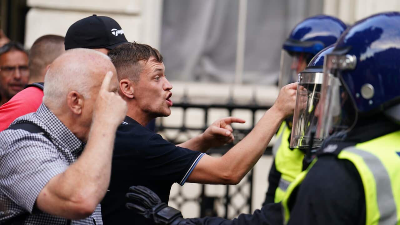 Two men verbally confronting policemen.