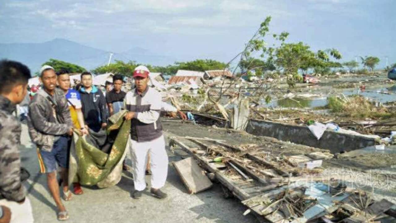 Rescuers on site of damaged city in Indonesia caused by earthquake and tsunami