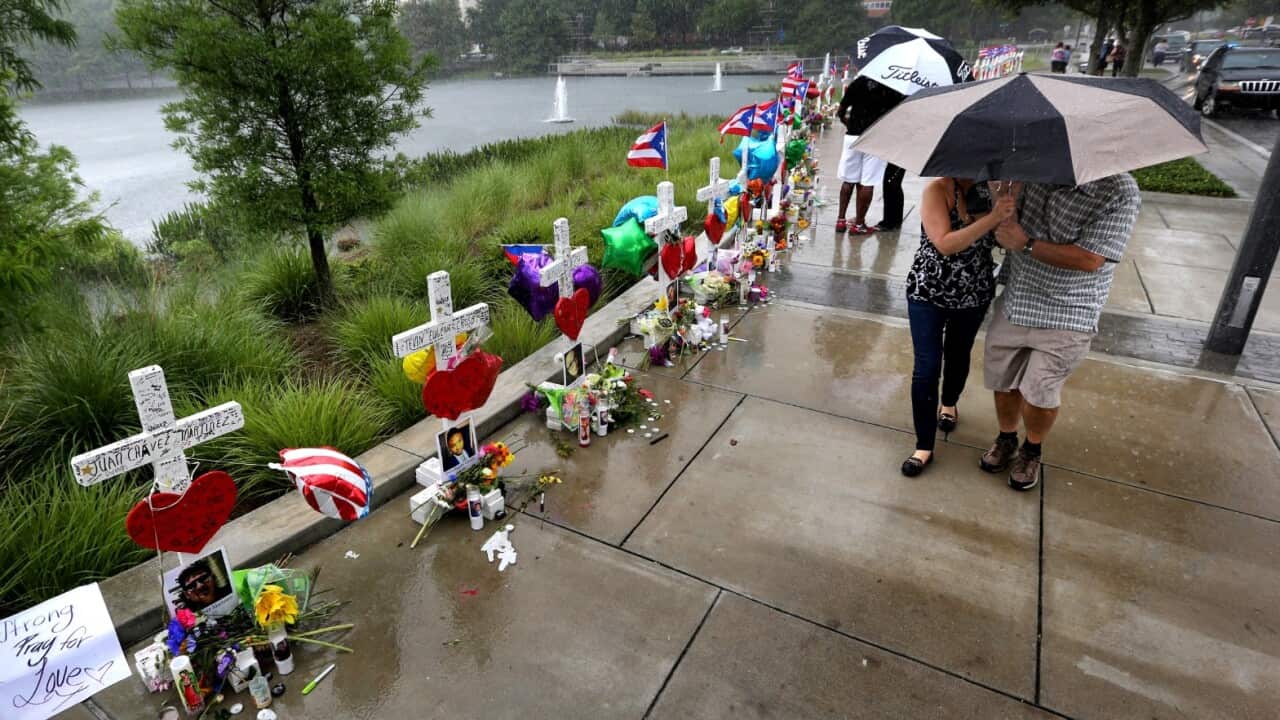 Visitors brave the rain to view the 49 crosses at the makeshift memorial outside Orlando Regional Medical Center, Sunday, June 19, 2016.