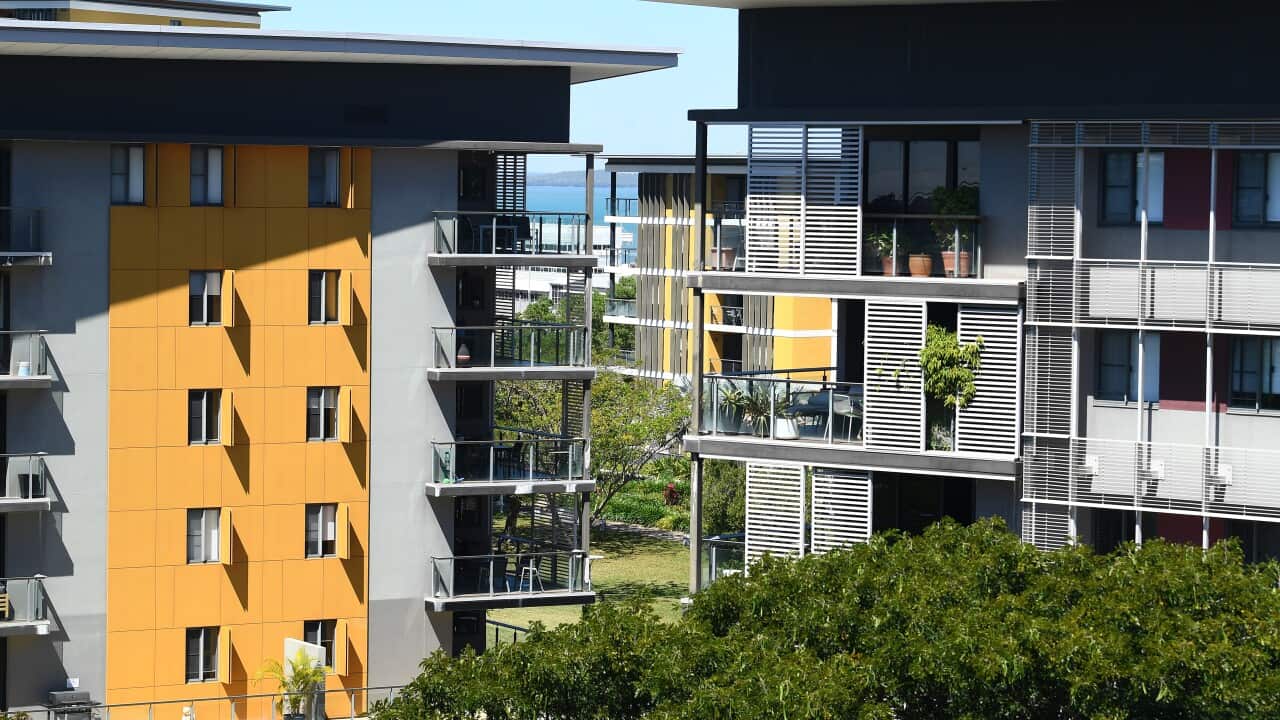 Several apartment buildings, surrounded by trees.