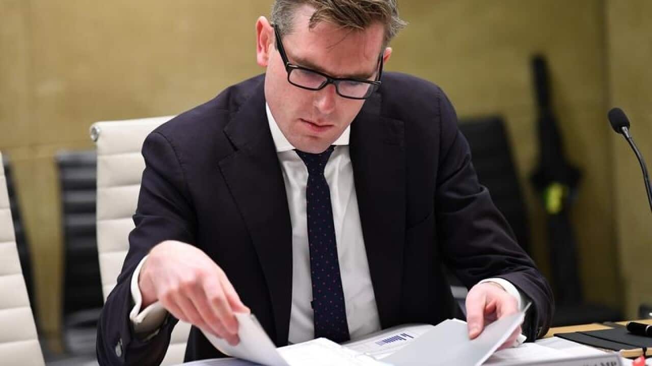 NSW Treasurer Dominic Perrottet looks at documents