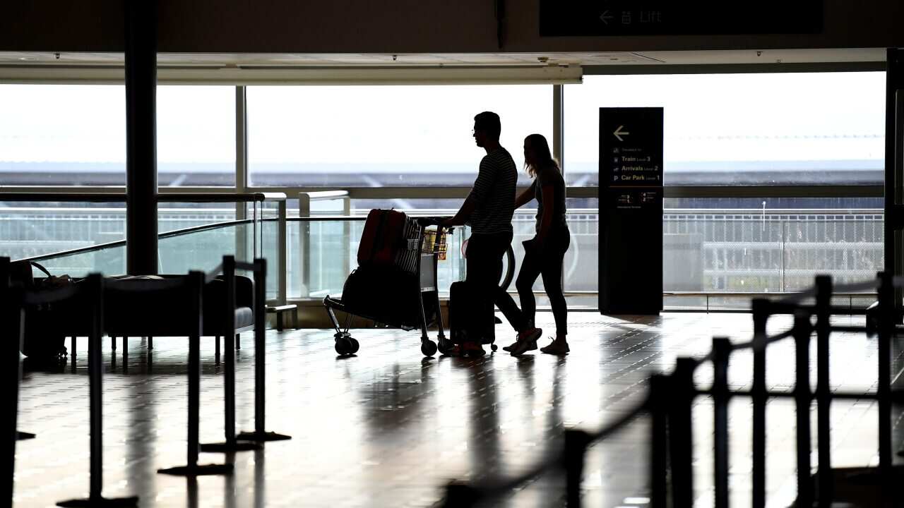 Travellers arrive to check in to one of only a handful of departing flights at the Brisbane international airport, Monday, March 30, 2020