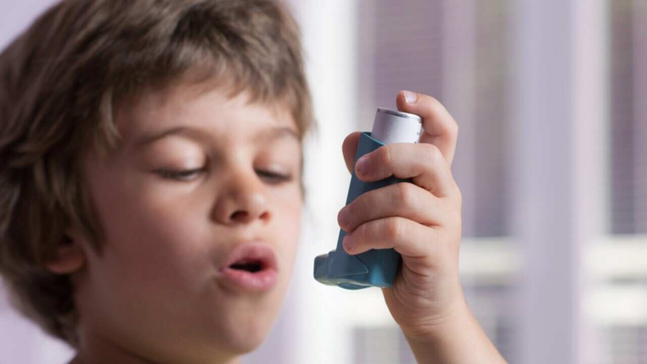 Boy using asthma inhaler to treat inflammatory disease, wheezing, coughing, chest tightness and shortness of breath. Allergy treating concept. Selective focus on inhaler.