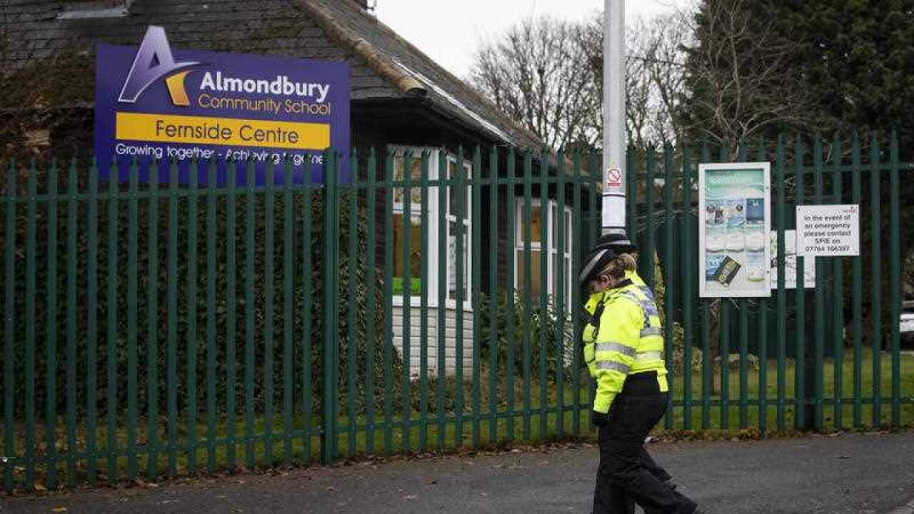 Police Community Support Officers walk past Almondbury Community School in Huddersfield where police are investigating a report of a "racially-aggravated assault" against a 15-year-old boy.