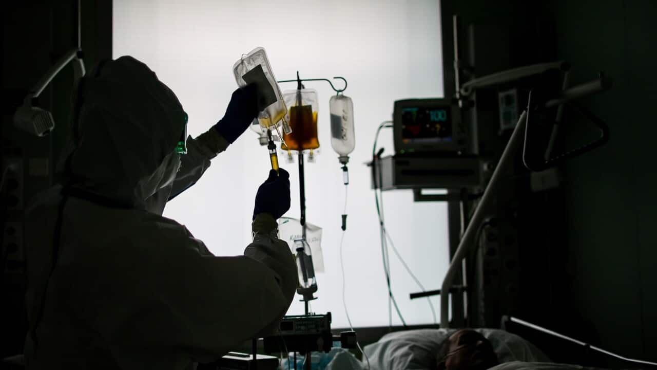 A health worker and a patient at an intensive care unit