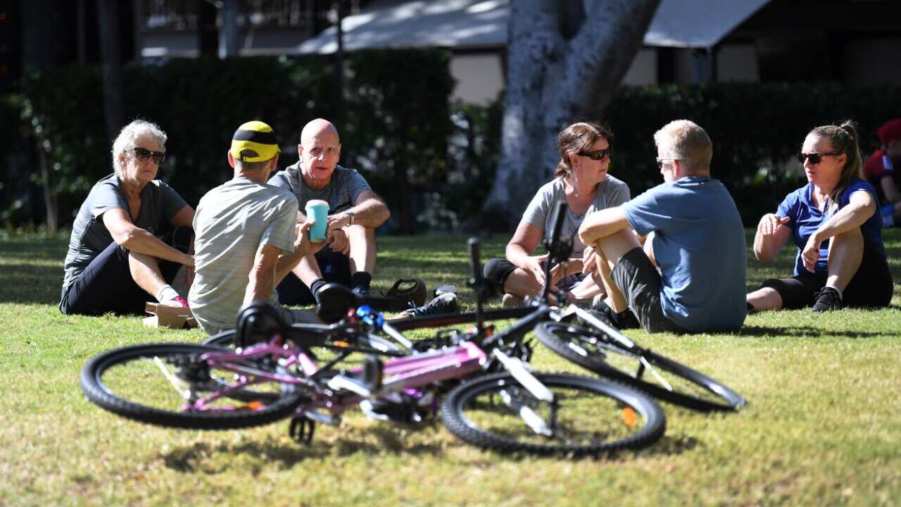 A group of people sit at a park in Southbank in Brisbane, Sunday, 17 May, 2020.