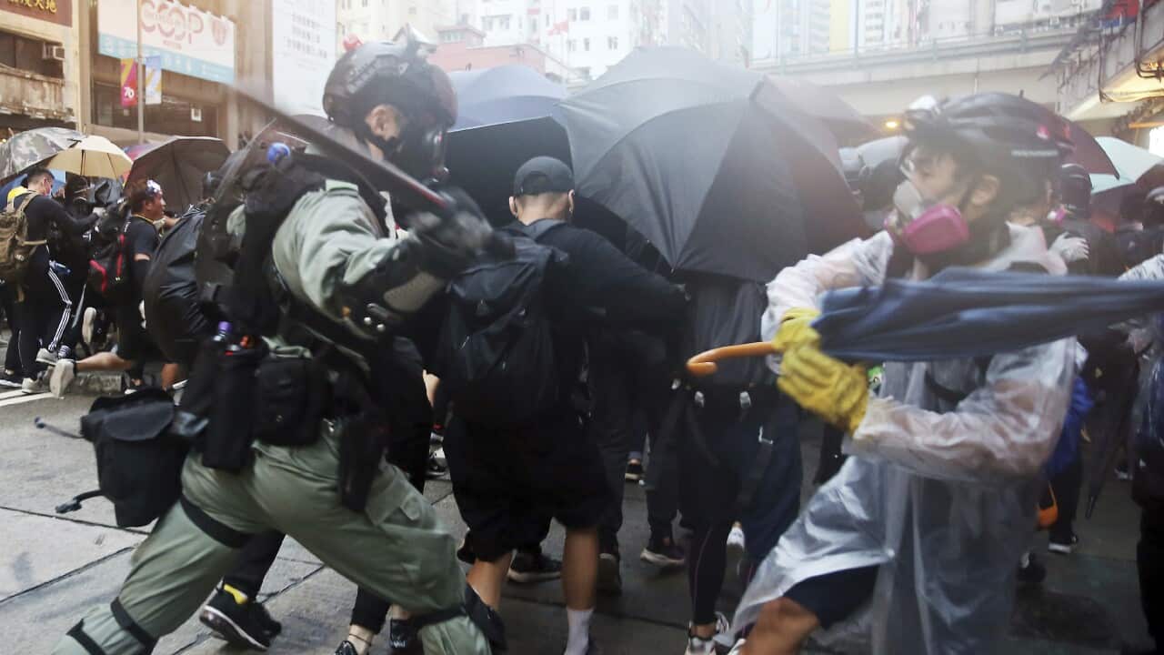 Police officers strike protesters with batons to catch up the protesters who participate in the demonstration in Hong Kong on October 6, 2019. The demonstrator fought back with umbrellas. ( The Yomiuri Shimbun via AP Images )