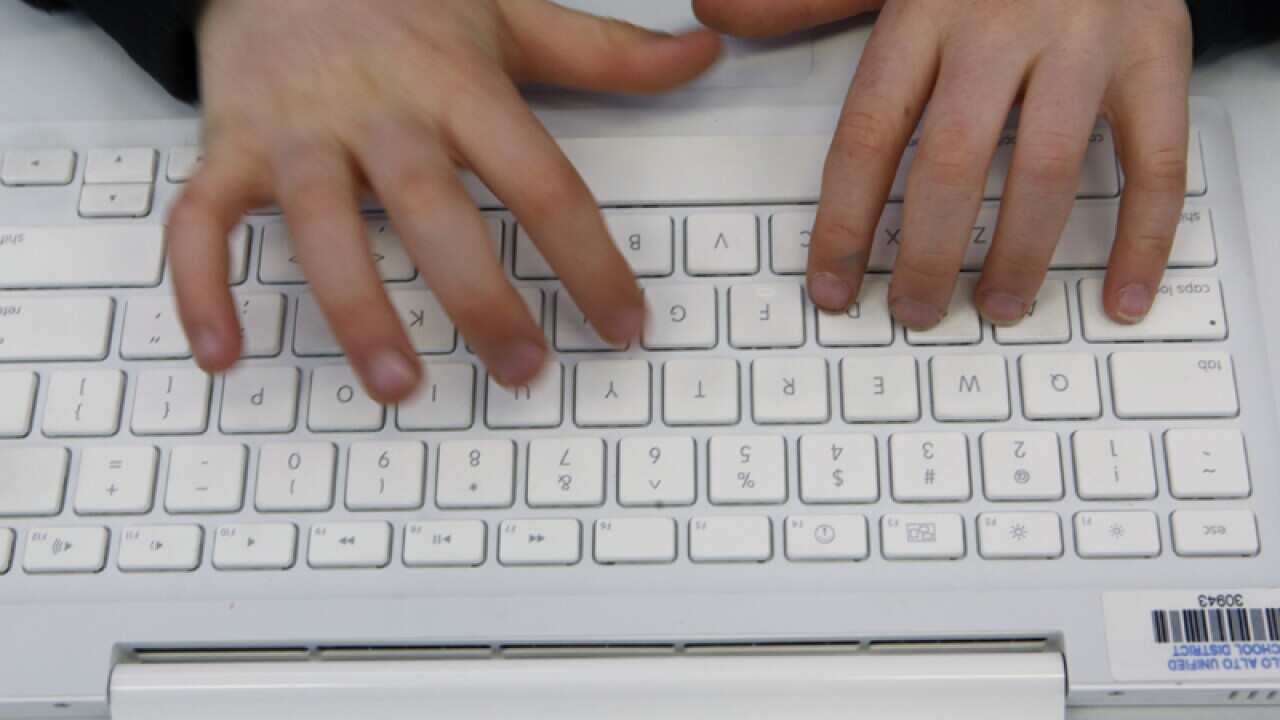 A student uses an Apple MacBook laptop