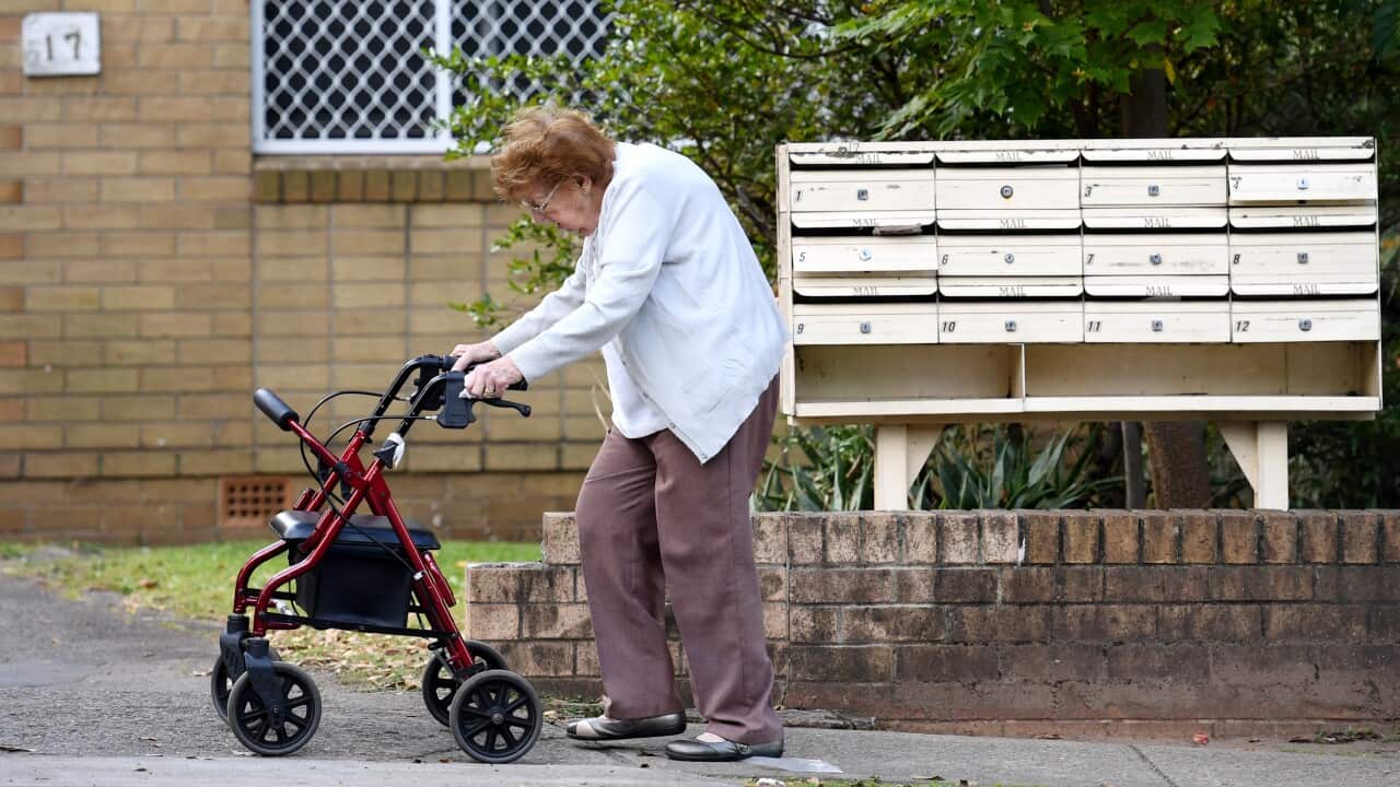 An elderly woman uses a mobility walker in Sydney.