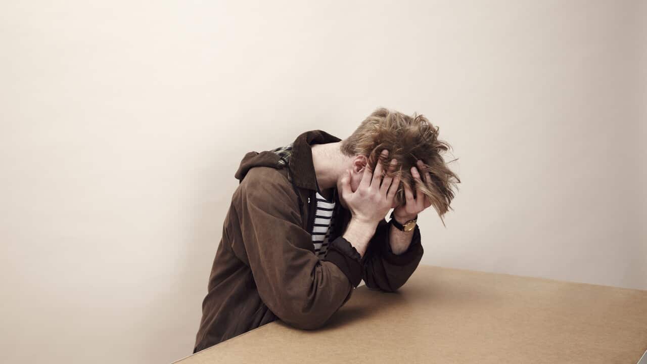 Portrait of man with his head in his hands