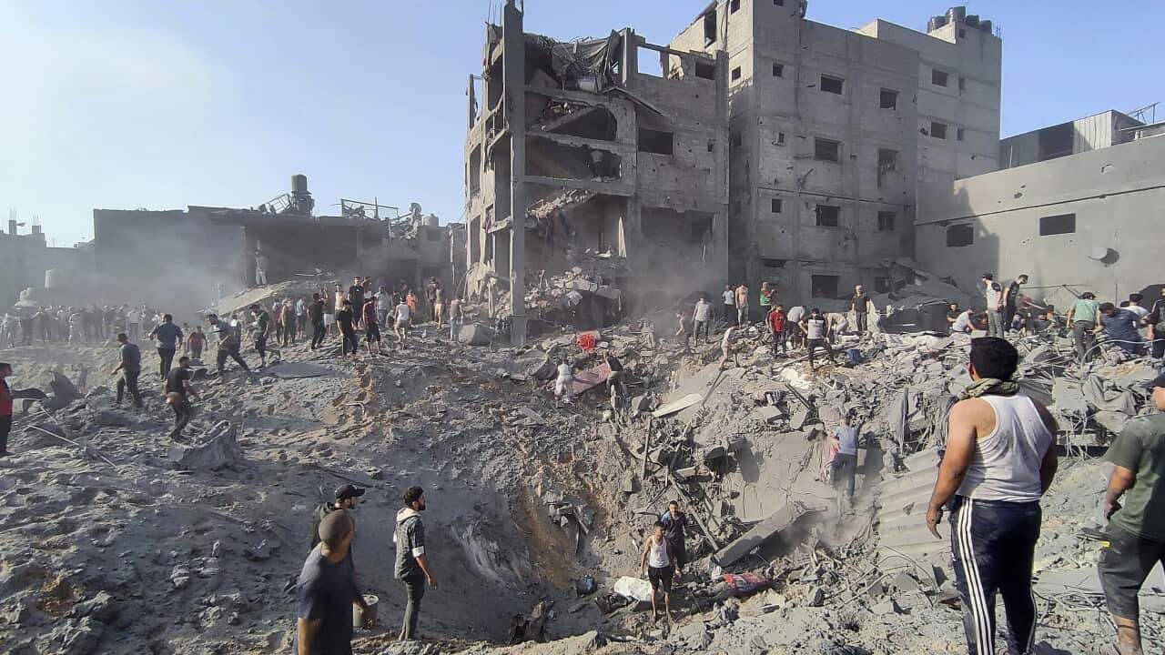 Palestinians inspect the damage of buildings destroyed by Israeli airstrikes.
