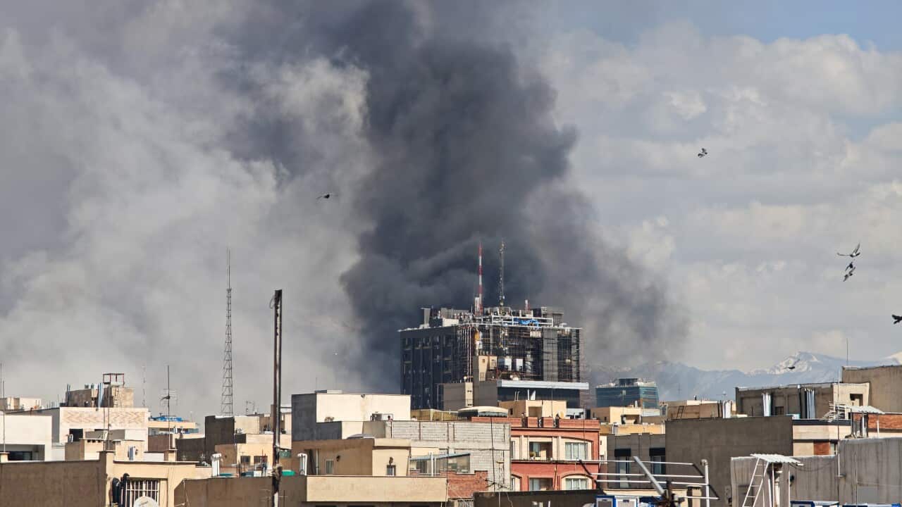 Smoke rising over buildings after a missile strike in a city