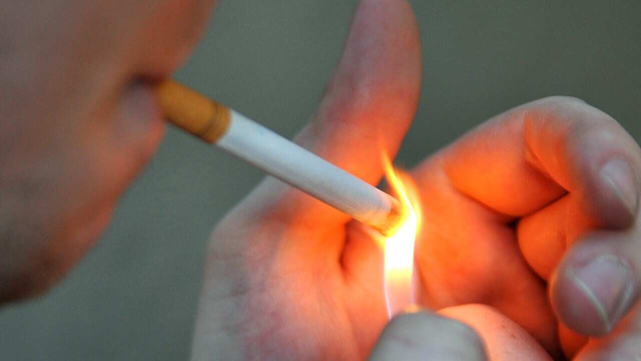 A man seen lighting a cigarette in Sydney